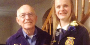 Christina stands with her Grandfather, "Papa Fred," wearing their blue jackets.