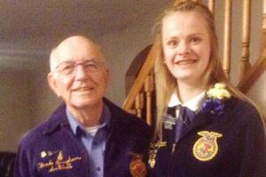 Christina stands with her Grandfather, "Papa Fred," wearing their blue jackets.