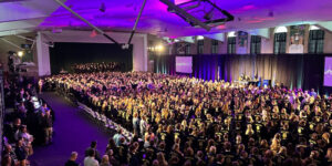 Modern-day photo of the 2024 North Dakota FFA State Convention at Bentson Bunker Fieldhouse, showing a packed house with FFA members in their iconic blue jackets.