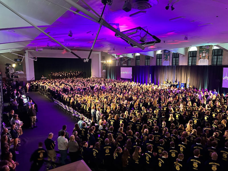 Modern-day photo of the 2024 North Dakota FFA State Convention at Bentson Bunker Fieldhouse, showing a packed house with FFA members in their iconic blue jackets.