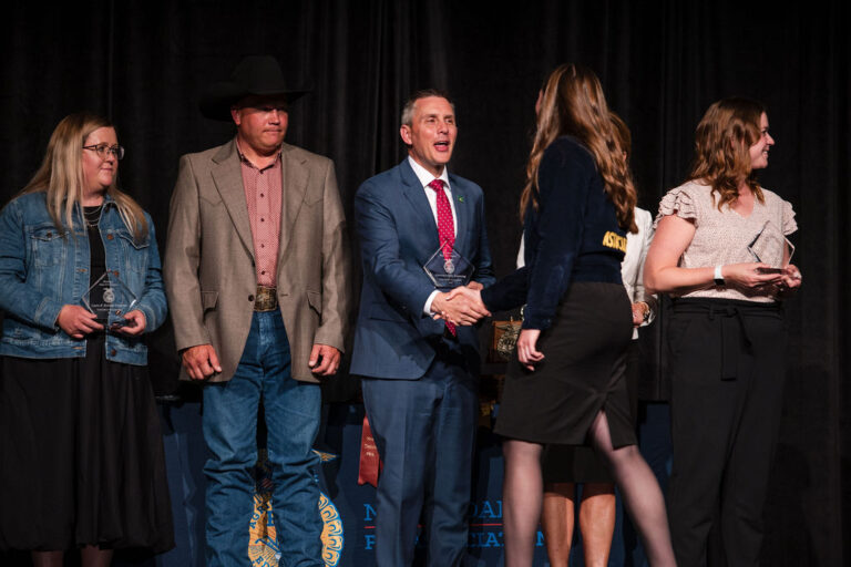 North Dakota Governor Kelly Armstrong shakes the hand of a state ffa officer as he accepts the honorary state degree at the 96th annual state ffa convention.