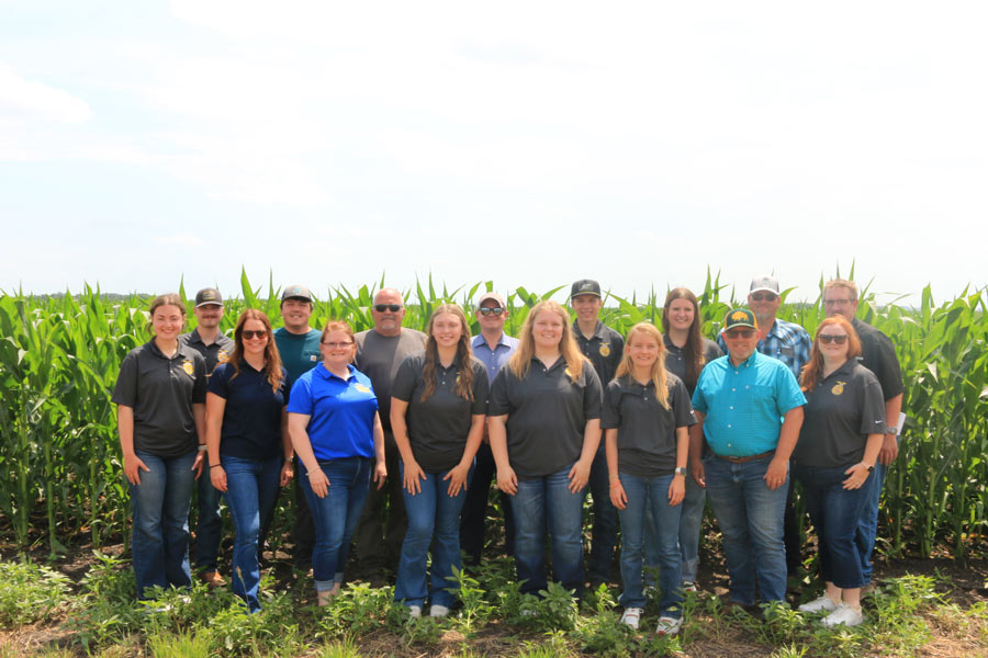 2026-27 North Dakota State FFA Officer team and Foundation staff and volunteers stand in front of a corn field located on the Bakk Farm.